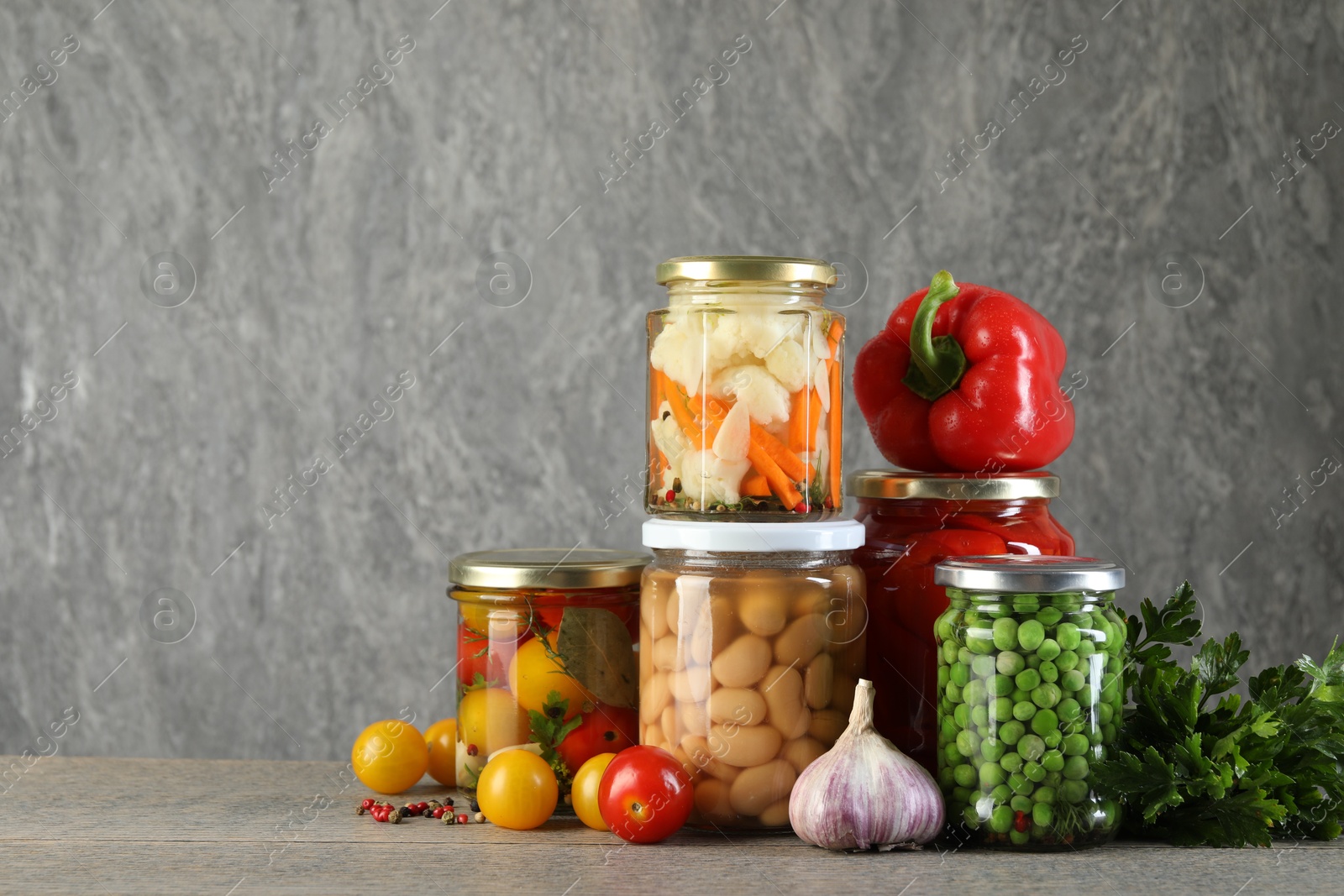 Photo of Different pickled products in jars on wooden table