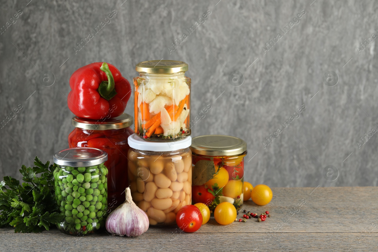 Photo of Different pickled products in jars on wooden table