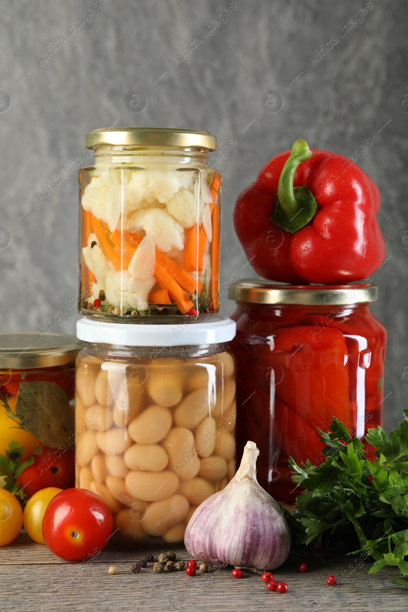 Photo of Different pickled products in jars on wooden table