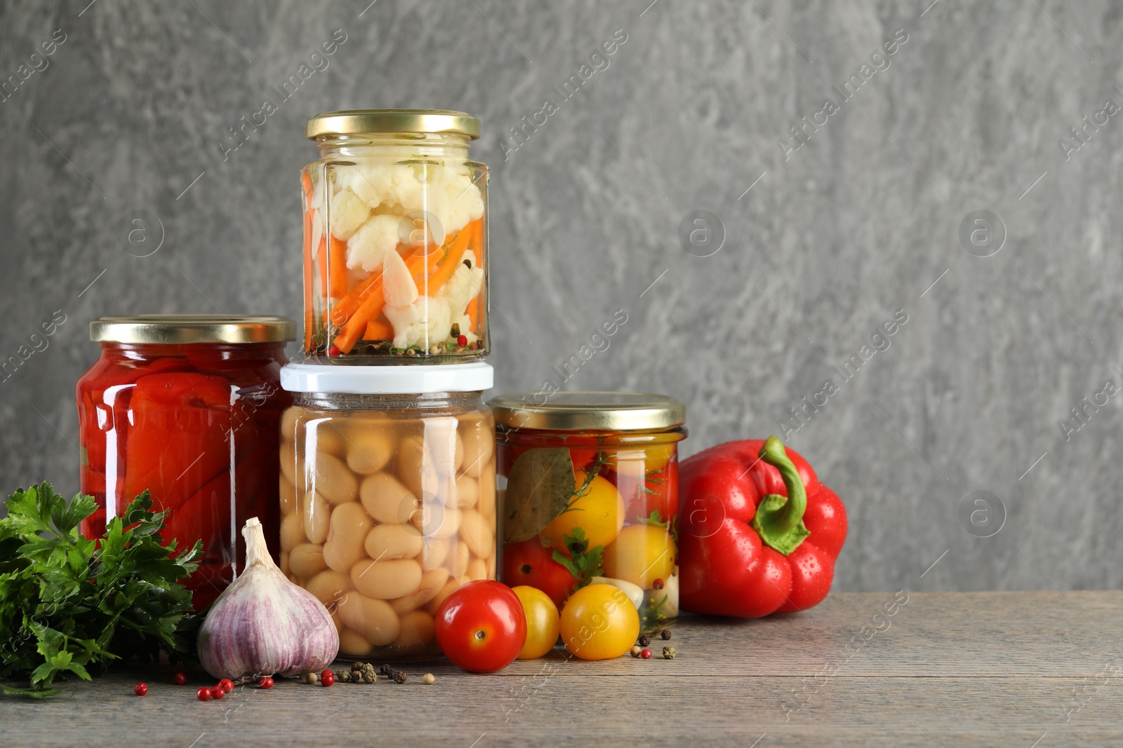 Photo of Different pickled products in jars on wooden table