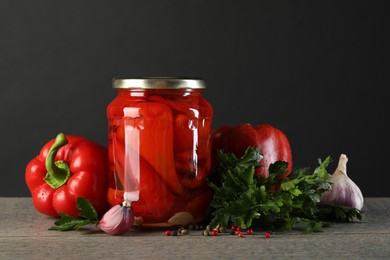 Photo of Tasty pickled vegetables in jar and fresh ingredients on wooden table