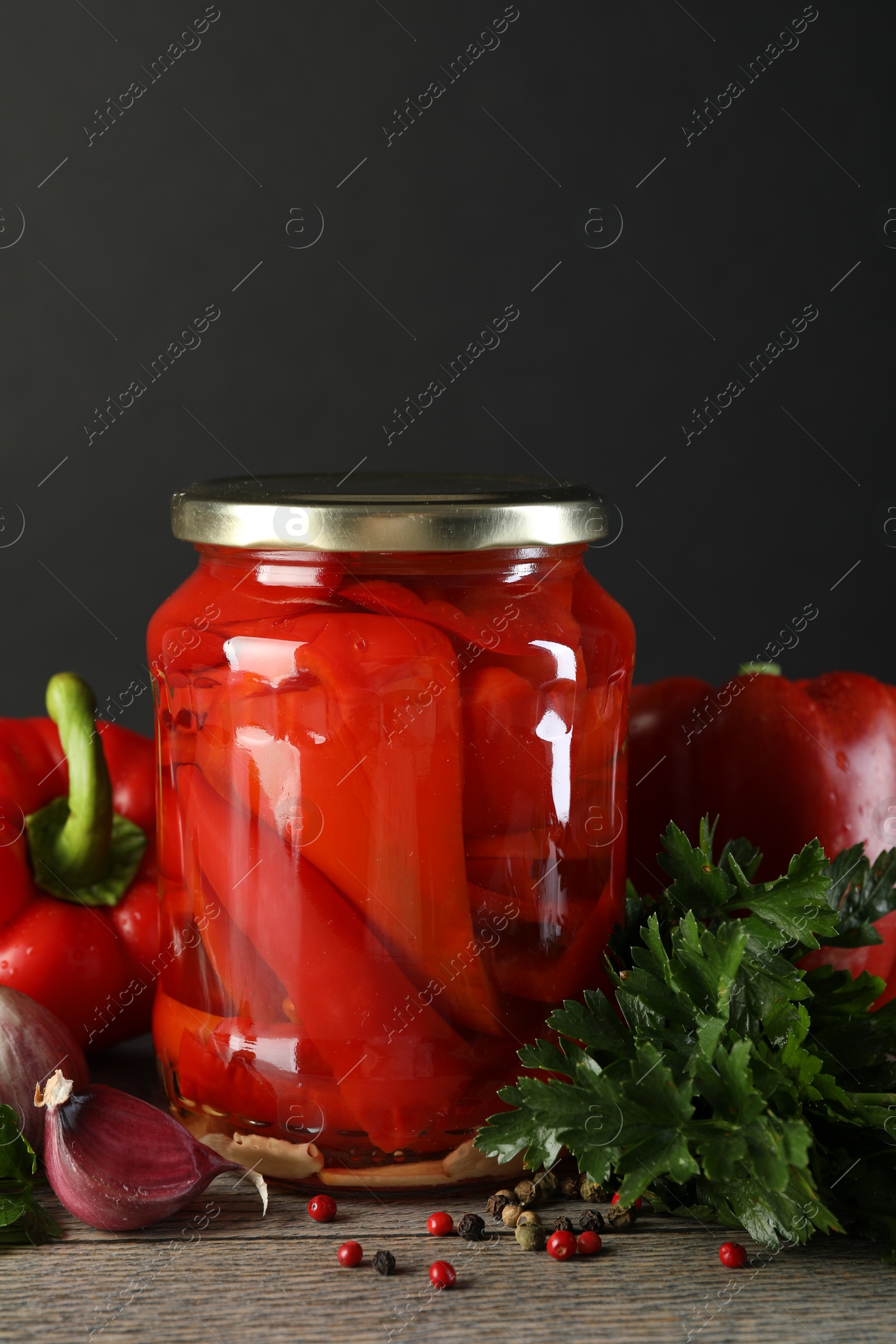 Photo of Tasty pickled vegetables in jar and fresh ingredients on wooden table