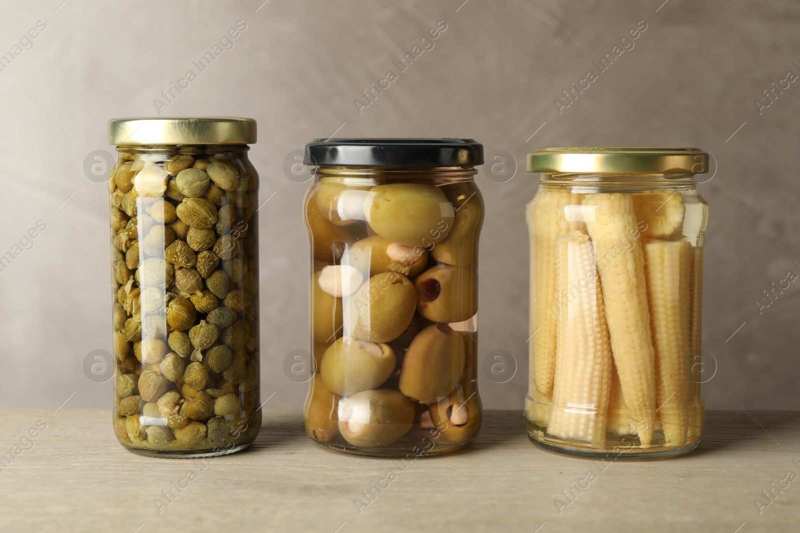 Photo of Different pickled products in jars on wooden table