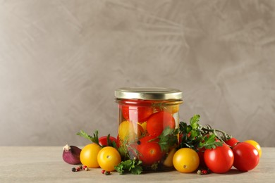 Photo of Different pickled tomatoes in jar and fresh ingredients on wooden table