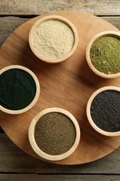 Photo of Different superfood powders in bowls on wooden table, top view