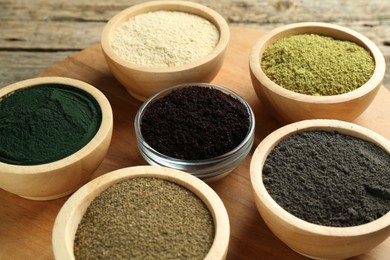 Different superfood powders in bowls on table, closeup