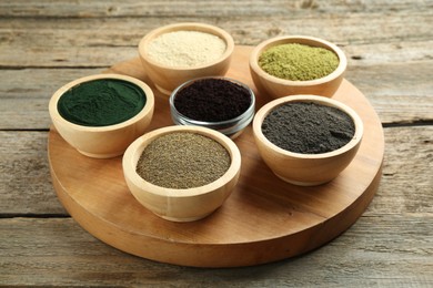 Different superfood powders in bowls on wooden table