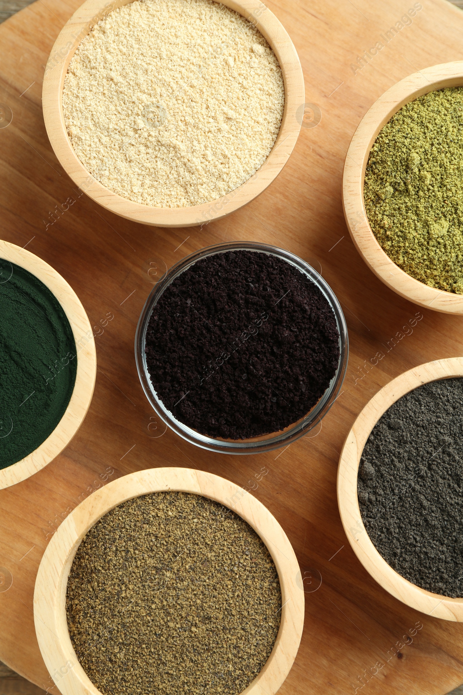 Photo of Different superfood powders in bowls on table, flat lay