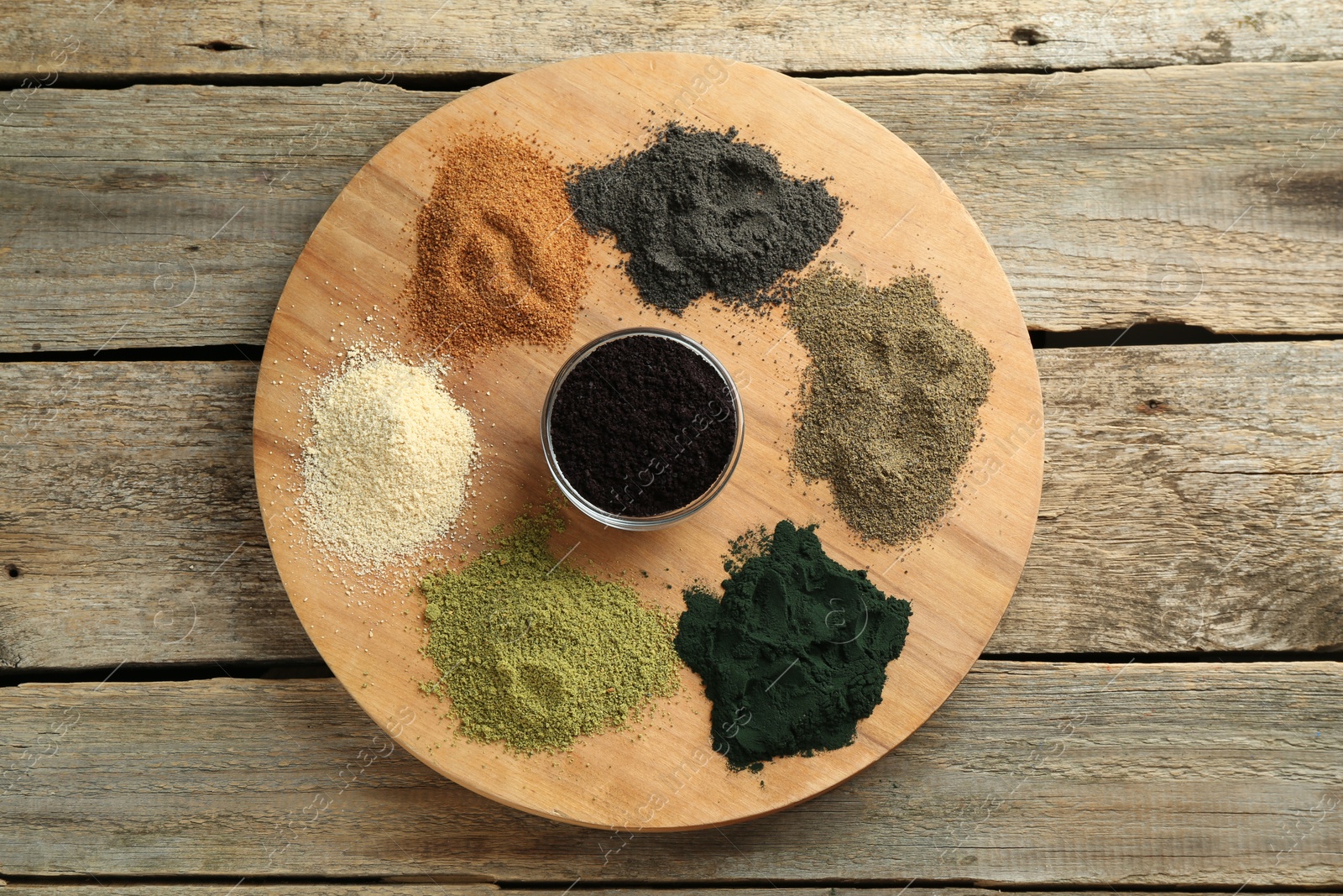 Photo of Different superfood powders on wooden table, top view