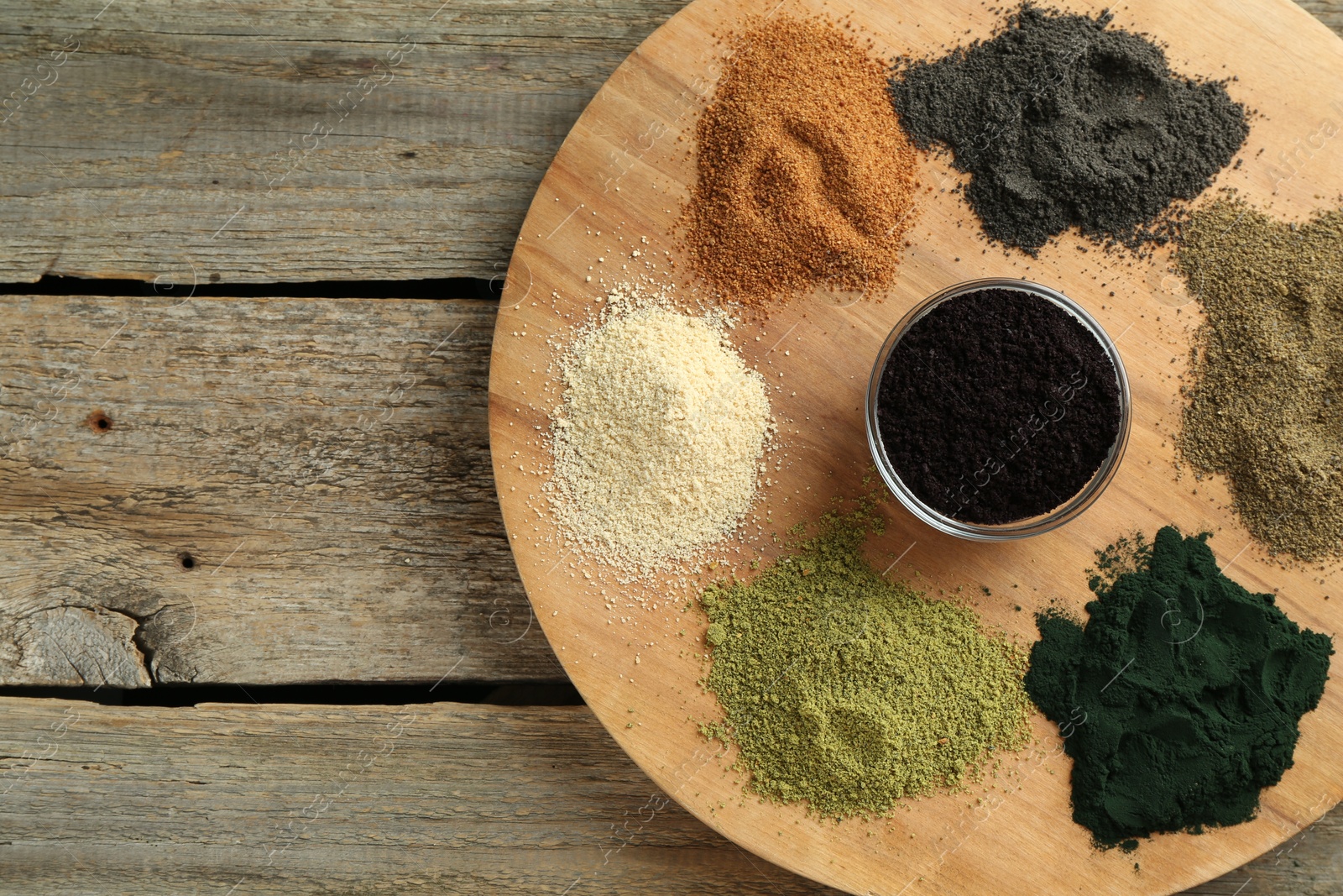 Photo of Different superfood powders on wooden table, top view. Space for text