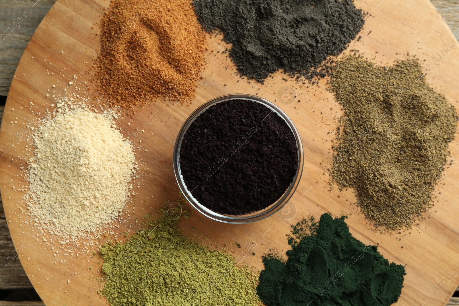 Photo of Different superfood powders on wooden table, top view