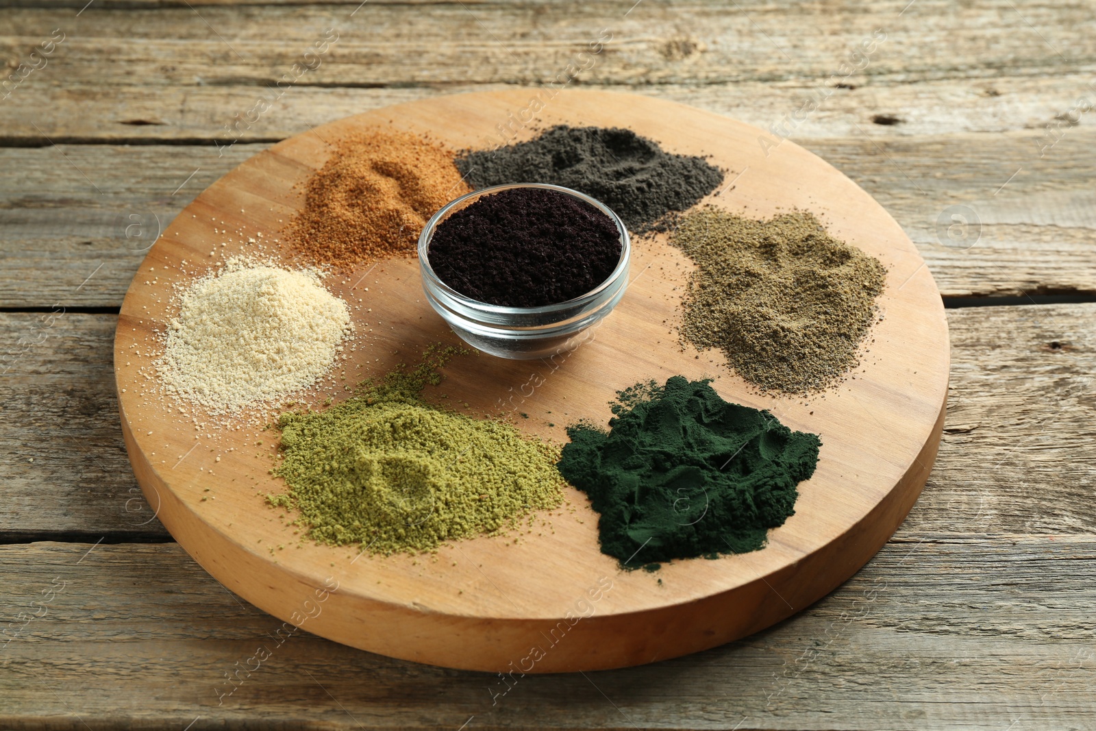 Photo of Different colorful superfood powders on wooden table