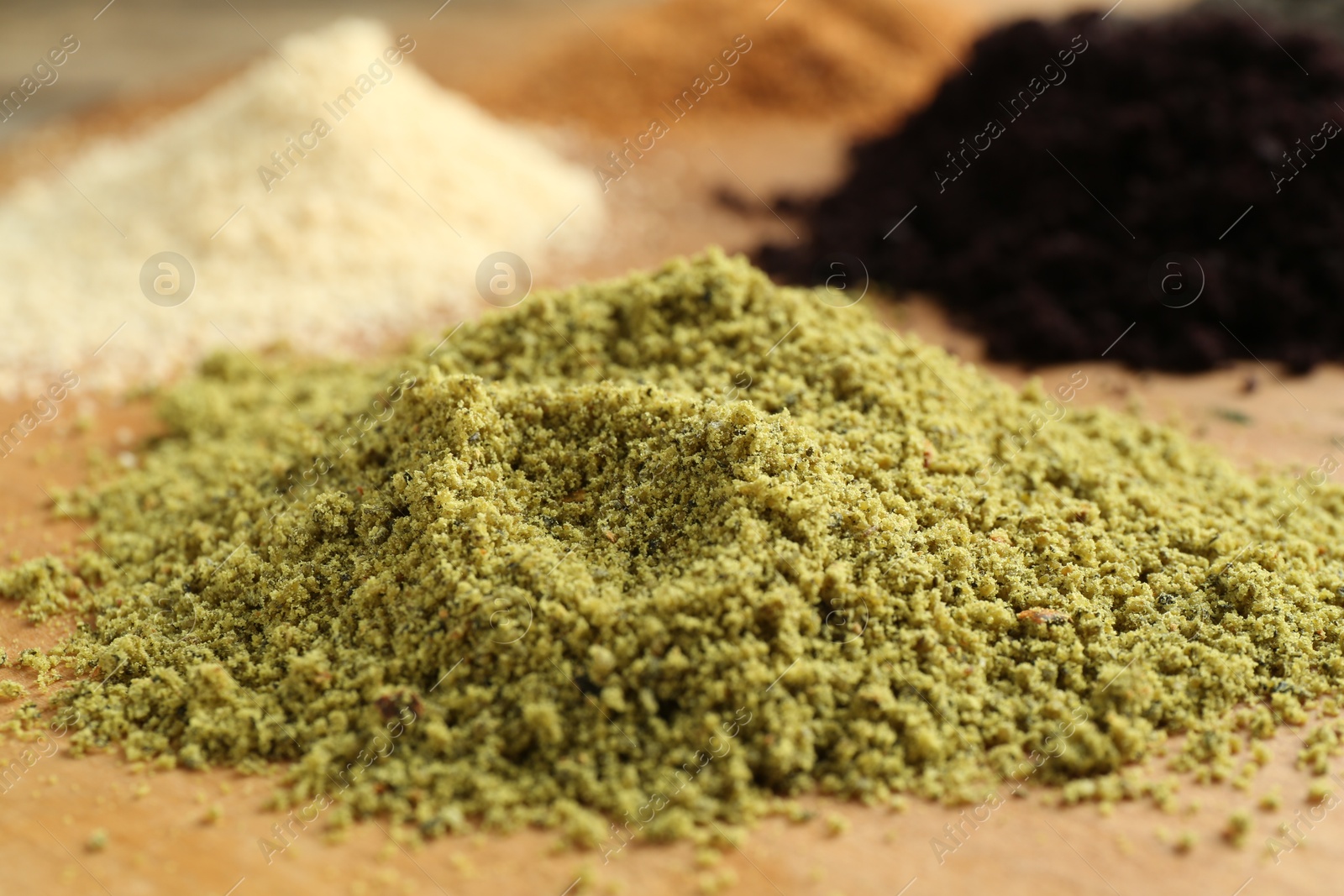 Photo of Different superfood powders on wooden table, closeup