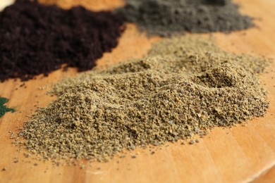 Photo of Different superfood powders on wooden table, closeup