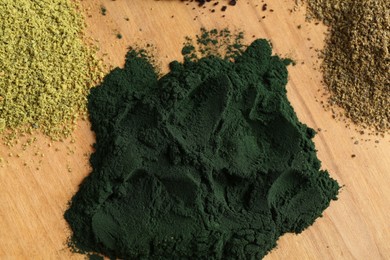 Different superfood powders on wooden table, flat lay