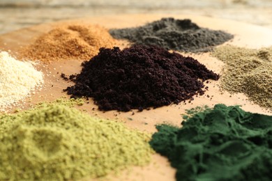 Photo of Different superfood powders on table, closeup view