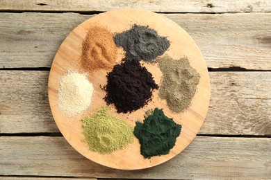 Different superfood powders on wooden table, top view