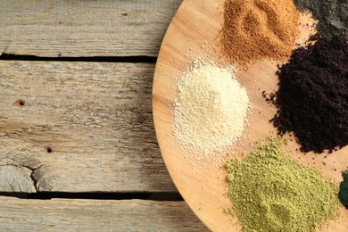 Photo of Different superfood powders on wooden table, top view. Space for text