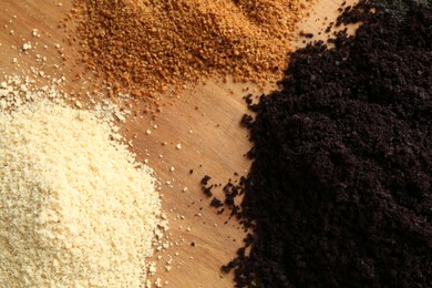 Different superfood powders on wooden table, closeup