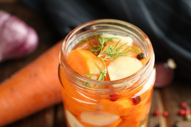 Photo of Tasty pickled carrots, garlic and dill in jar on table, closeup