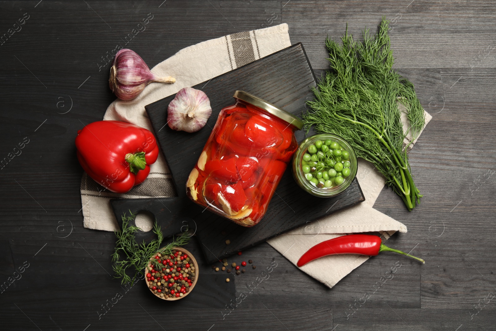 Photo of Different pickled products in jars and fresh ingredients on grey wooden table, top view