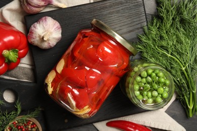 Photo of Different pickled products in jars and fresh ingredients on table, top view