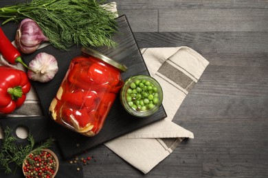 Photo of Different pickled products in jars and fresh ingredients on grey wooden table, top view. Space for text