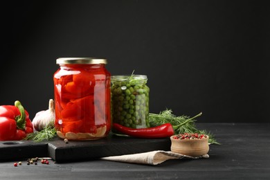 Photo of Different pickled products in jars and fresh ingredients on grey wooden table