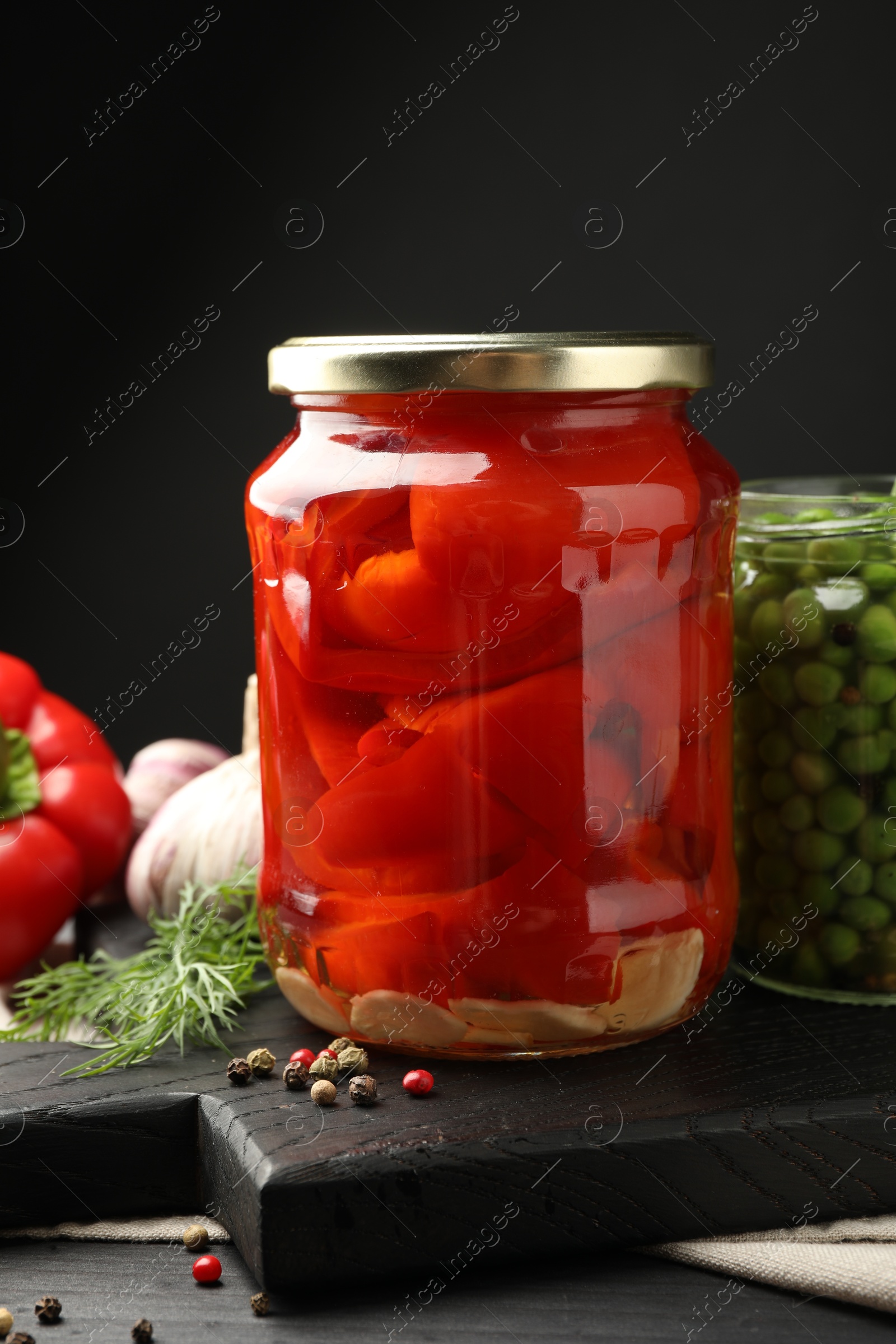 Photo of Different pickled products in jars and fresh ingredients on grey wooden table, closeup