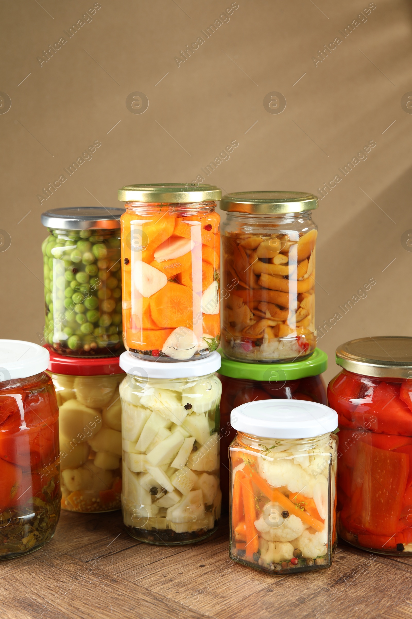 Photo of Different pickled products in jars on wooden table