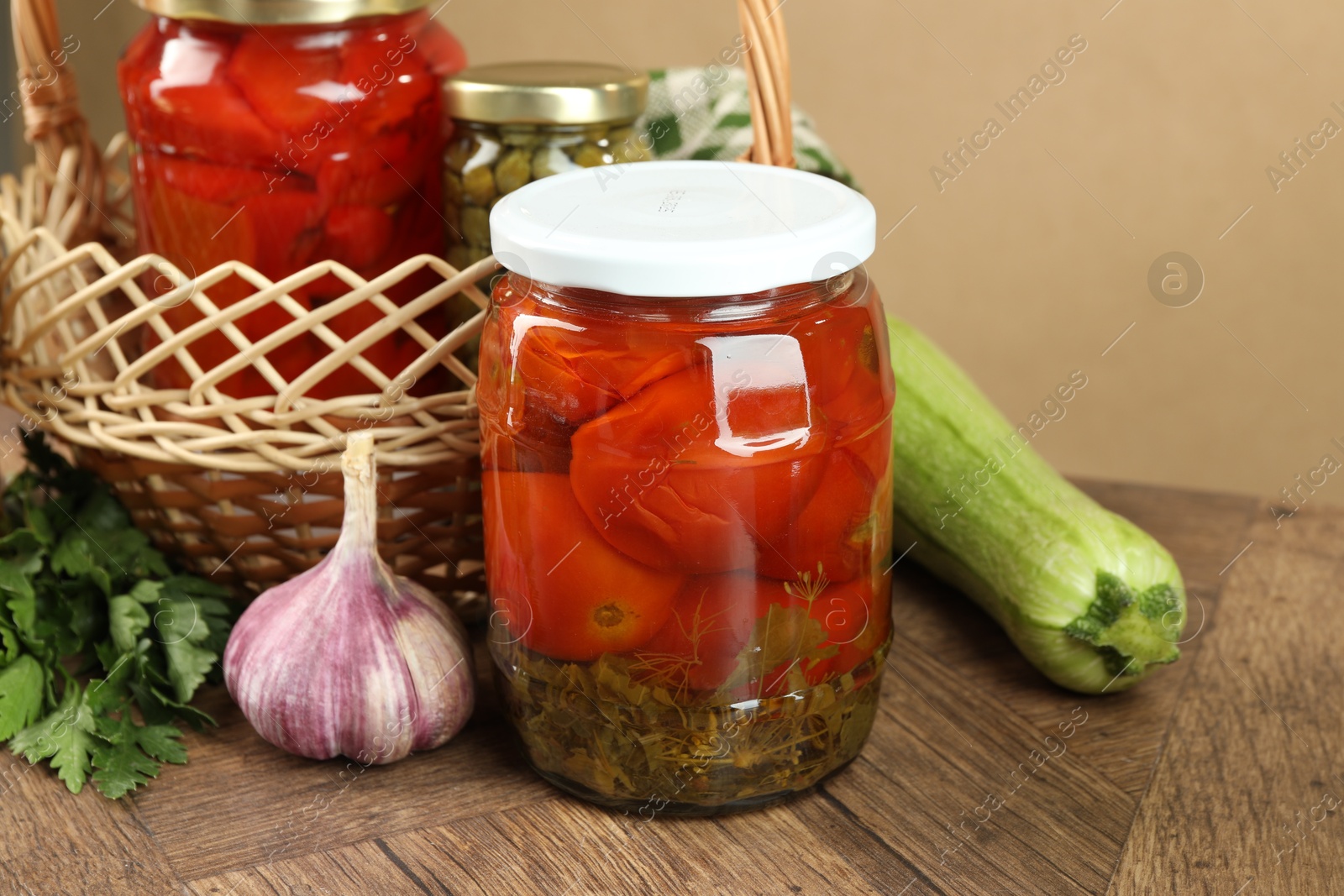 Photo of Different pickled products in jars and fresh ingredients on wooden table