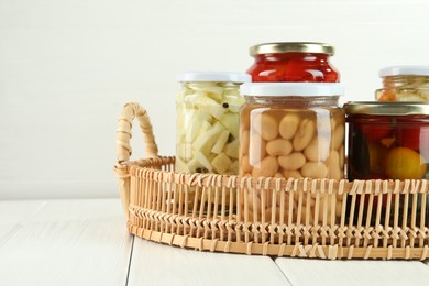 Photo of Different pickled products in jars on white wooden table