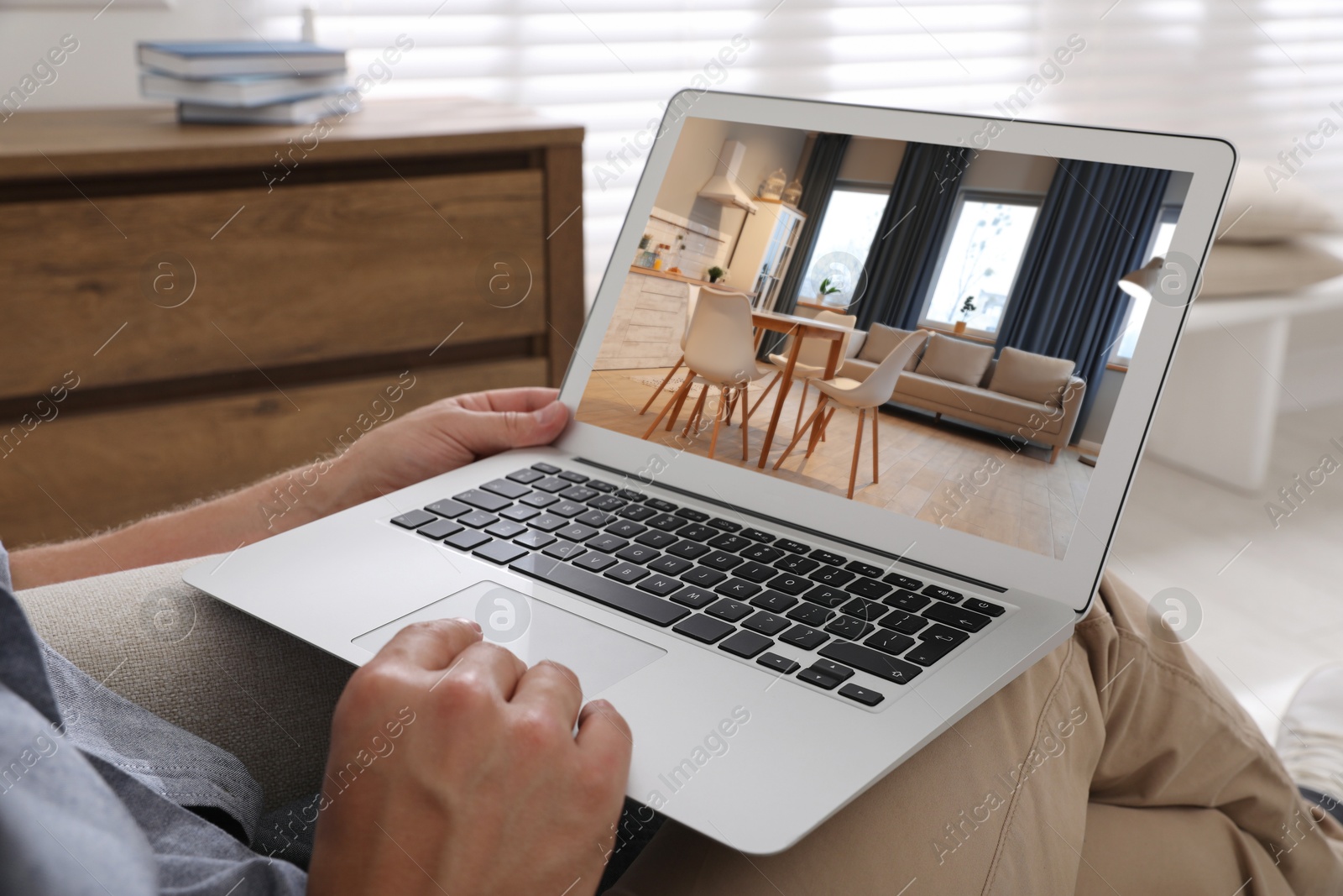 Image of Man looking for house on real estate market website at home, closeup