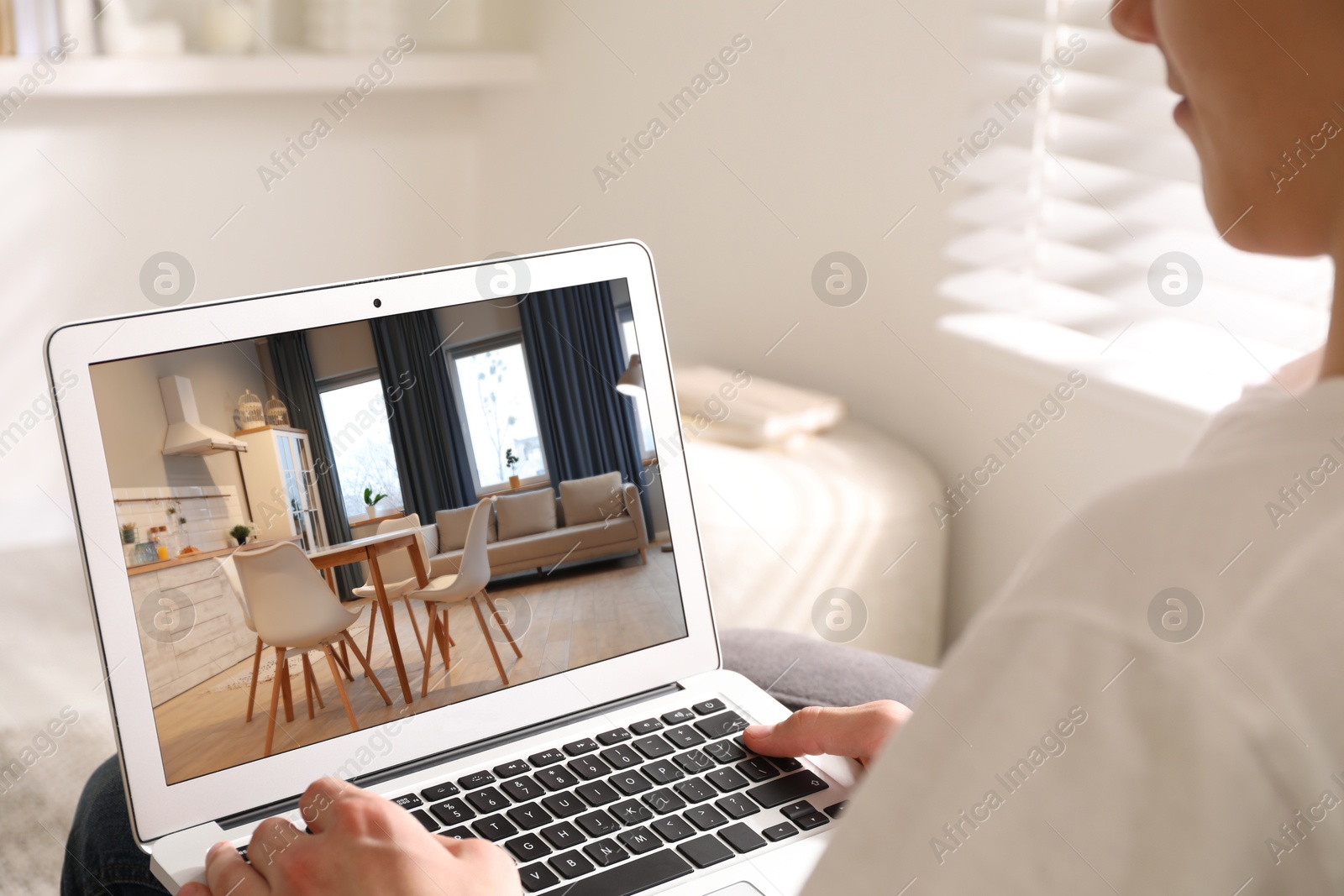 Image of Man looking for house on real estate market website at home, closeup