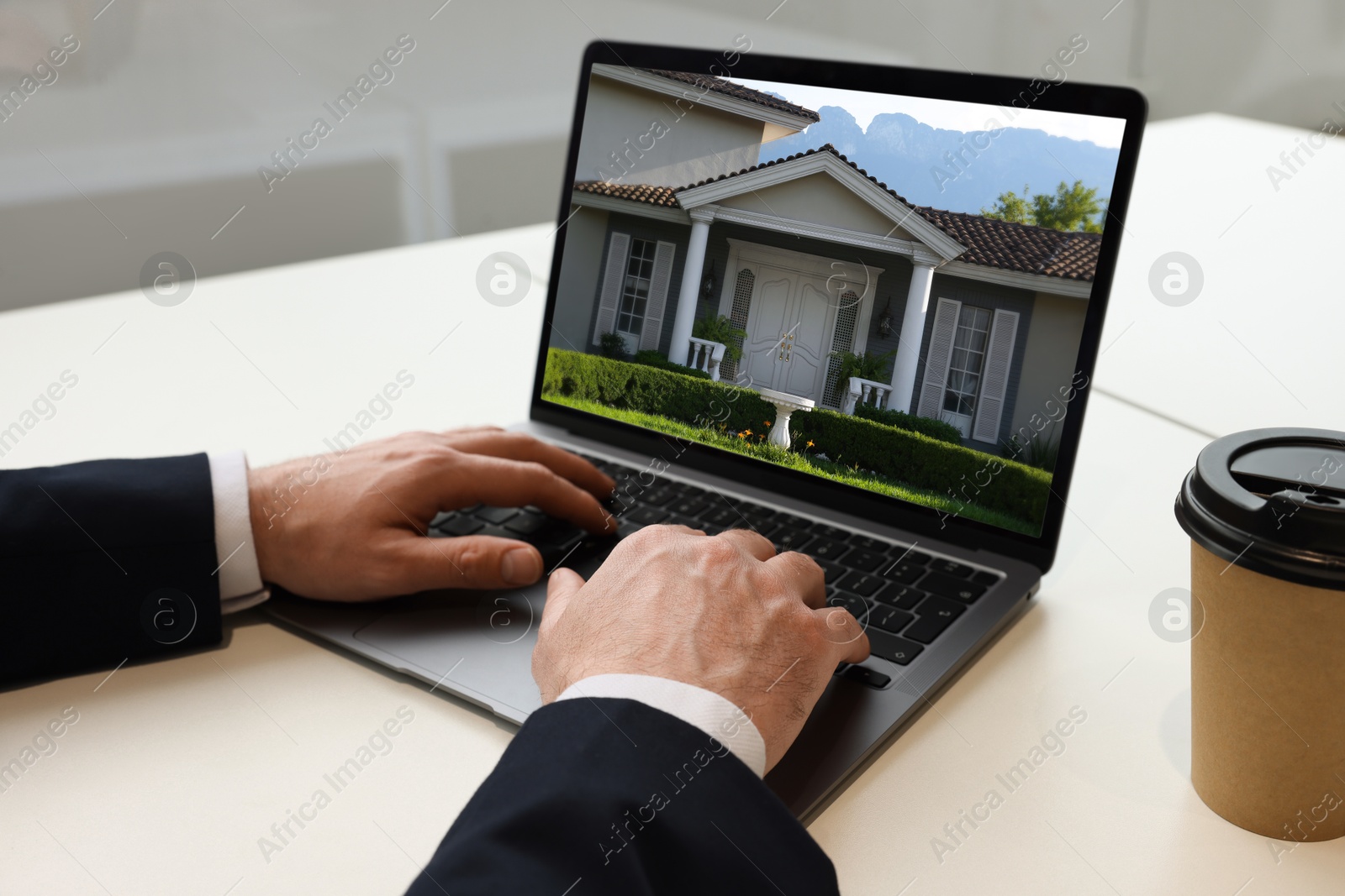 Image of Man looking for house on real estate market website at table, closeup