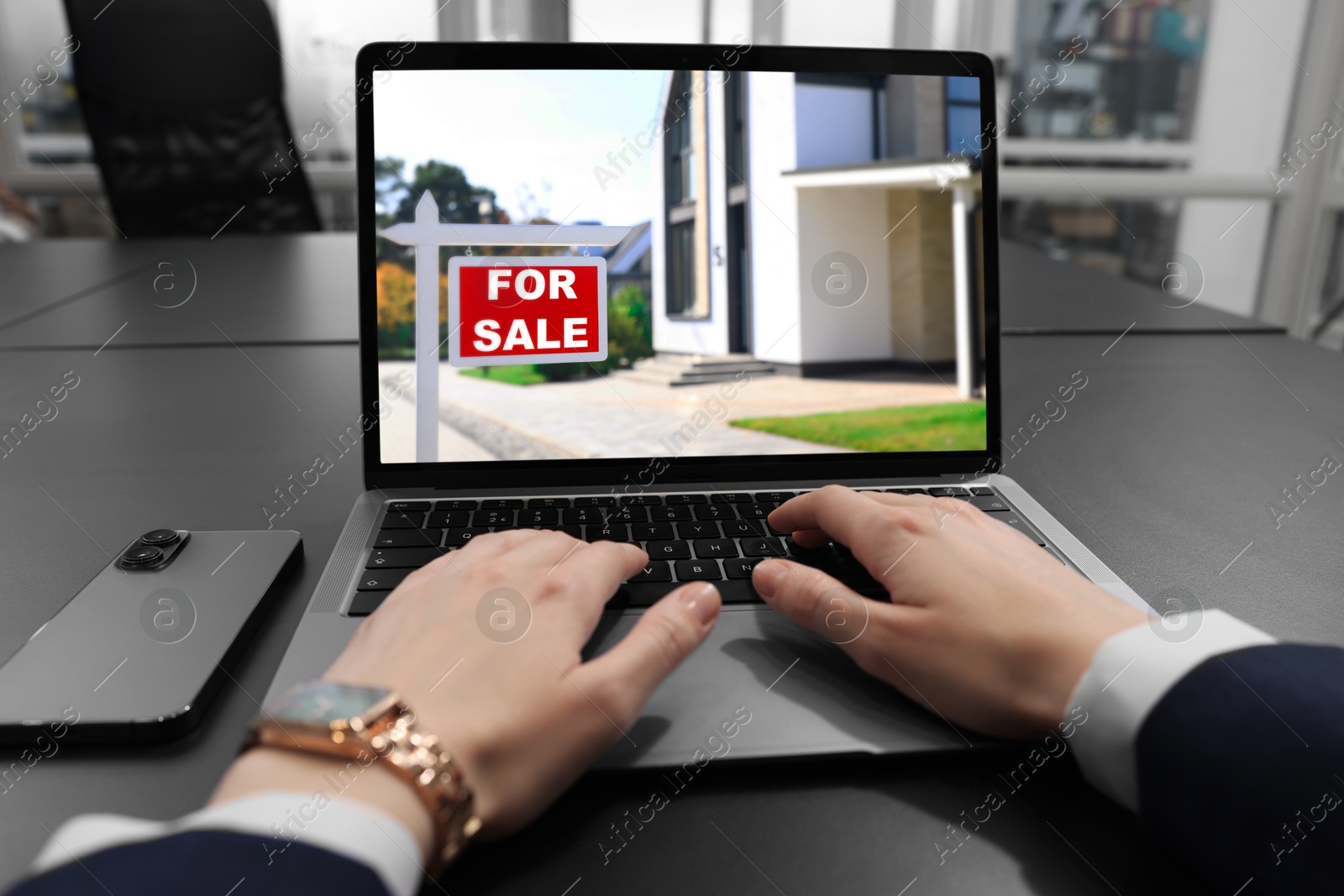 Image of Woman looking for house on real estate market website at table, closeup