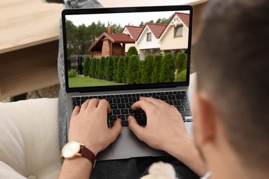 Image of Man looking for house on real estate market website at home, closeup