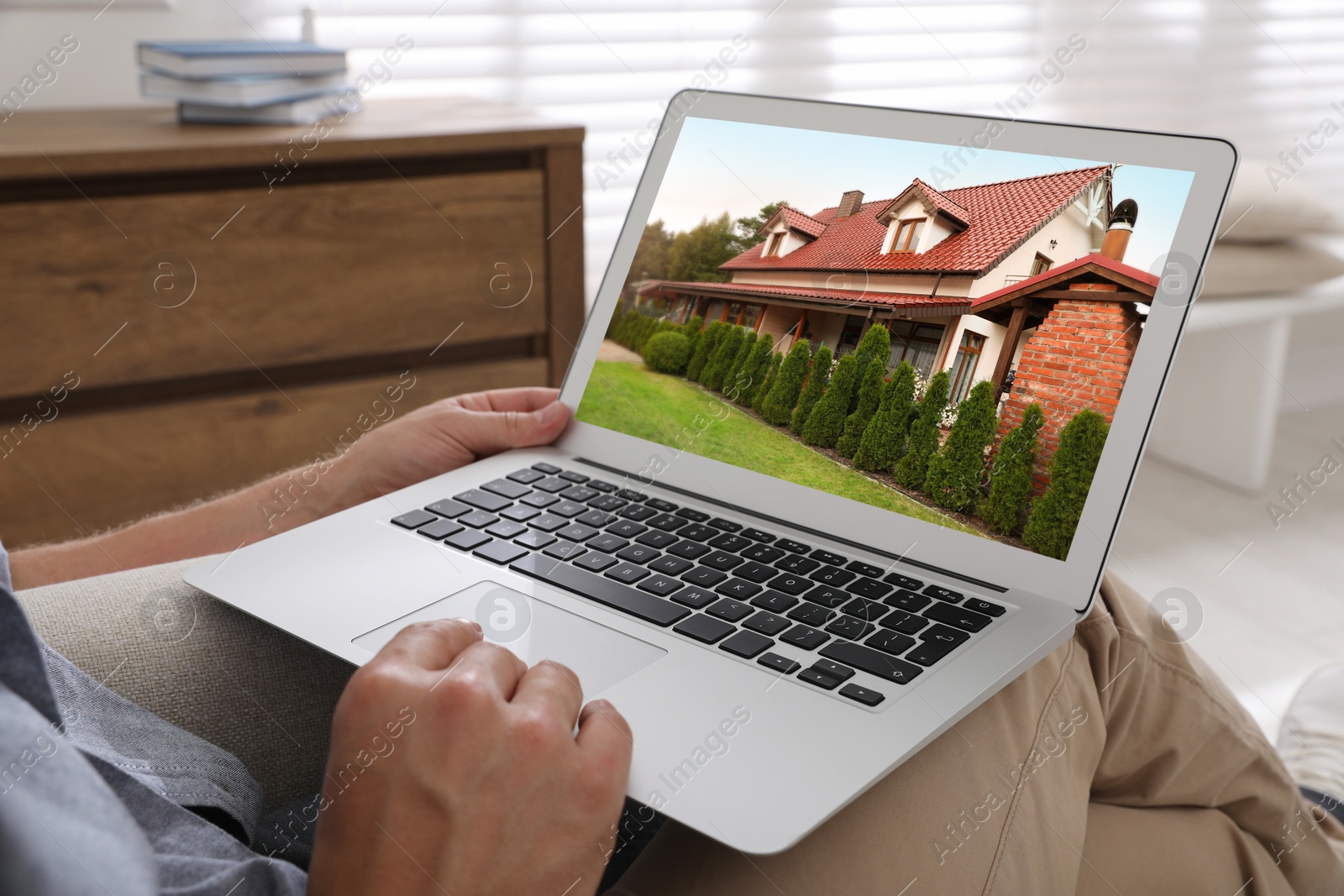 Image of Man looking for house on real estate market website at home, closeup