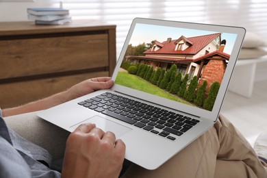 Man looking for house on real estate market website at home, closeup