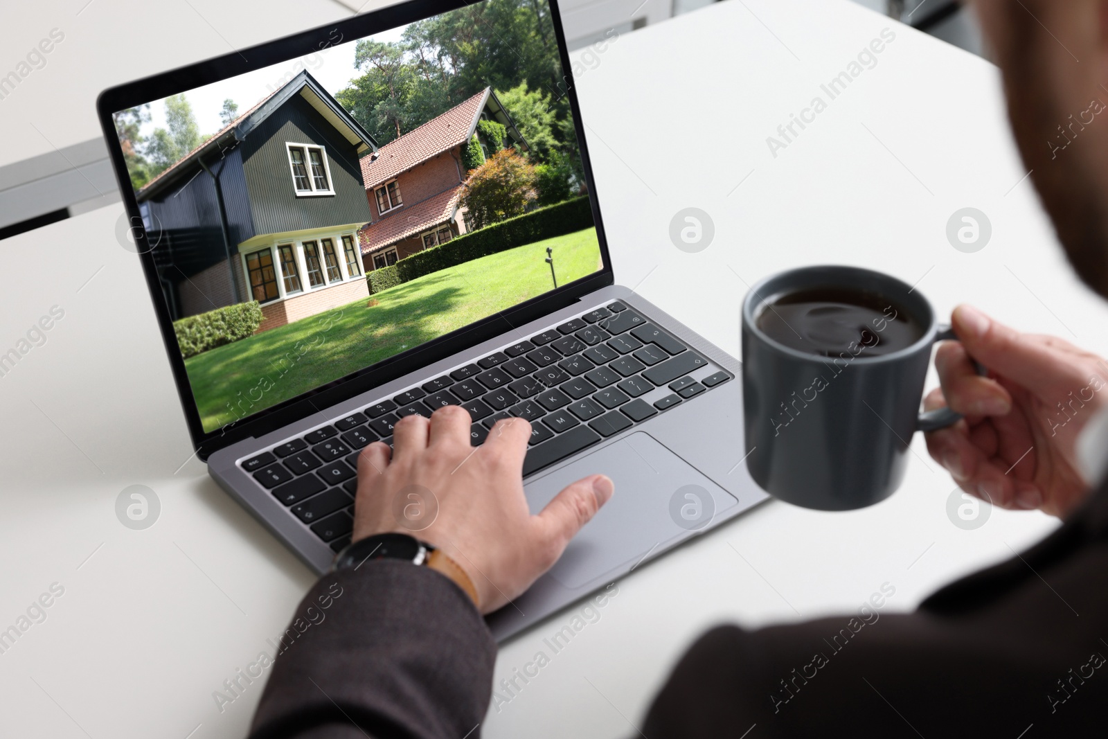 Image of Man looking for house on real estate market website at table, closeup