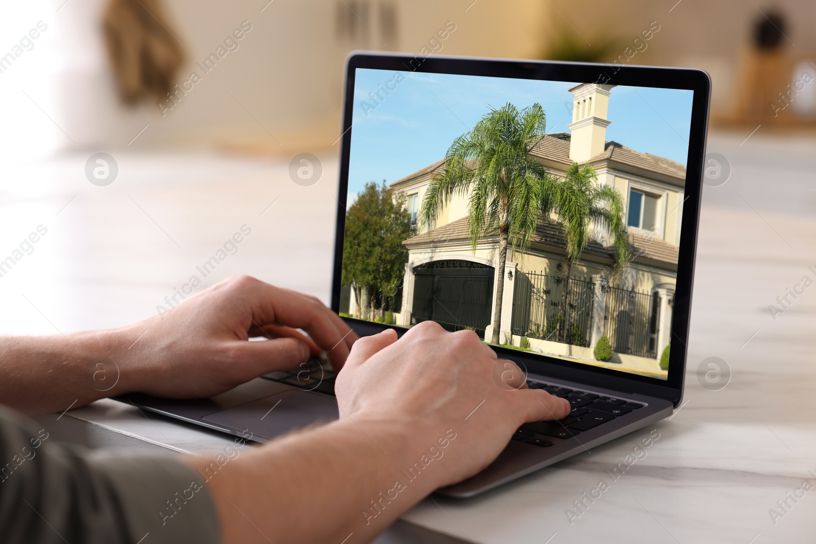 Image of Man looking for house on real estate market website at table, closeup