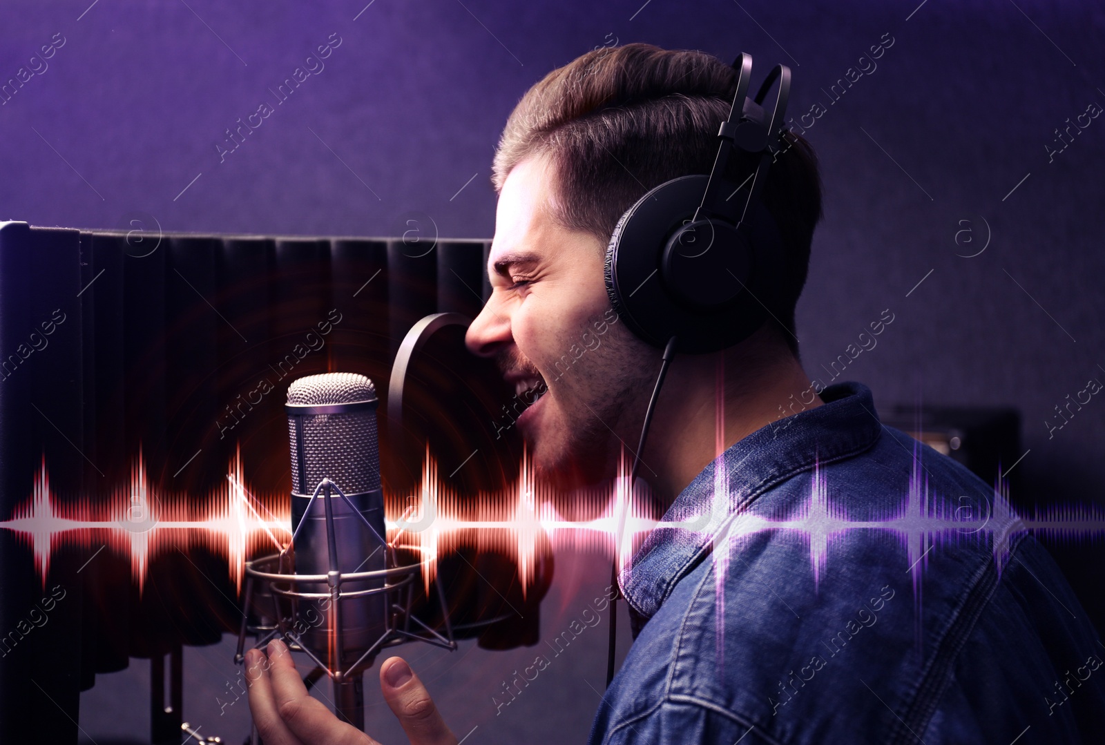 Image of Young singer with microphone recording song in studio. Audio waveform near him