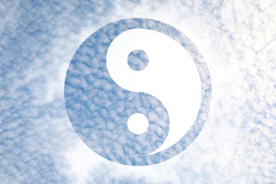 Image of Yin and yang symbol against sky, double exposure