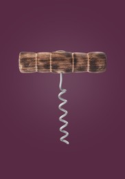 Image of Corkscrew with wooden handle on dark purple background