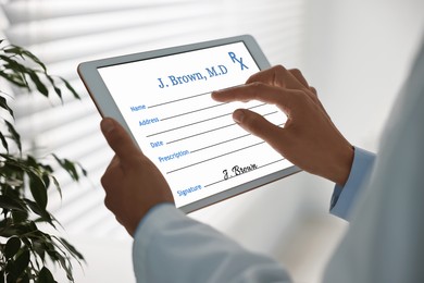 Image of Doctor filling in medical prescription on tablet in clinic, closeup