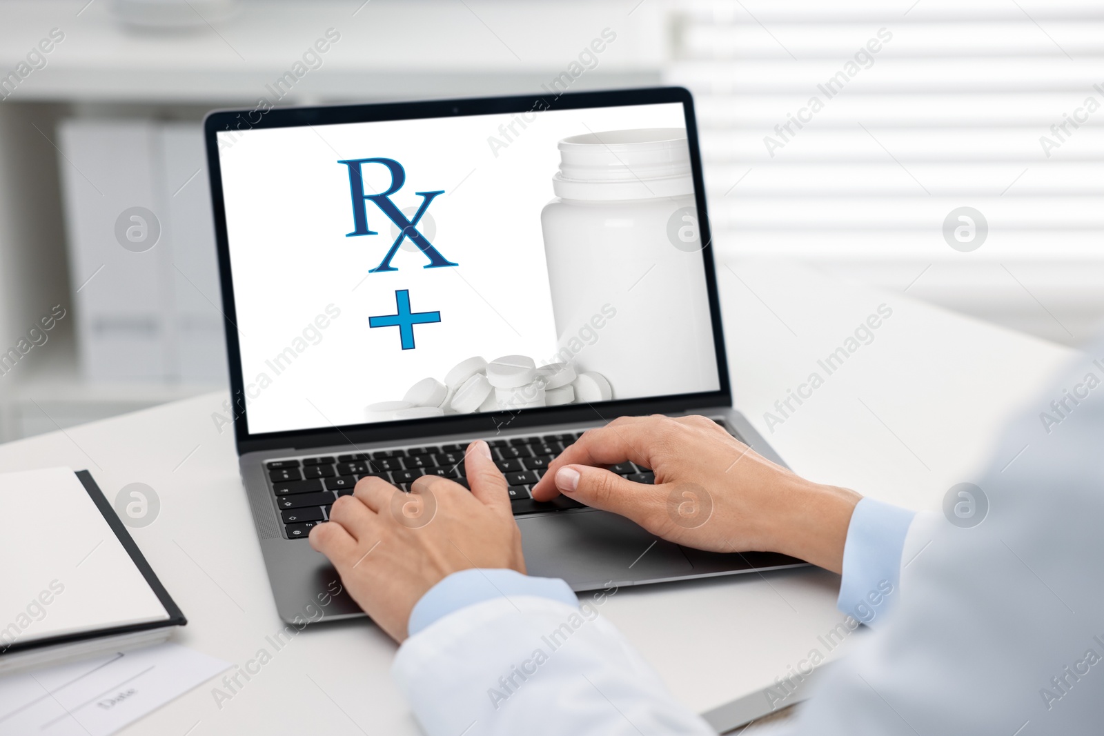 Image of Medical prescription. Doctor working on laptop at table in clinic, closeup