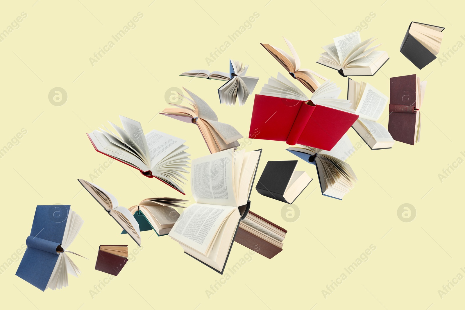 Image of Many different books in air on light yellow background