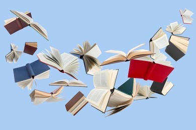 Image of Many different books in air on light blue background