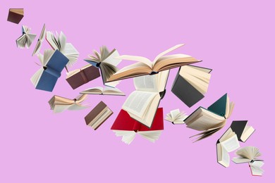 Image of Many different books in air on light violet background