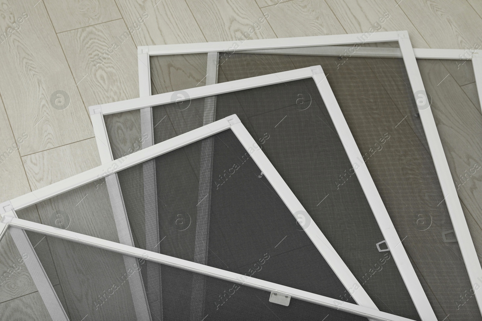 Photo of Set of window screens on wooden floor, closeup